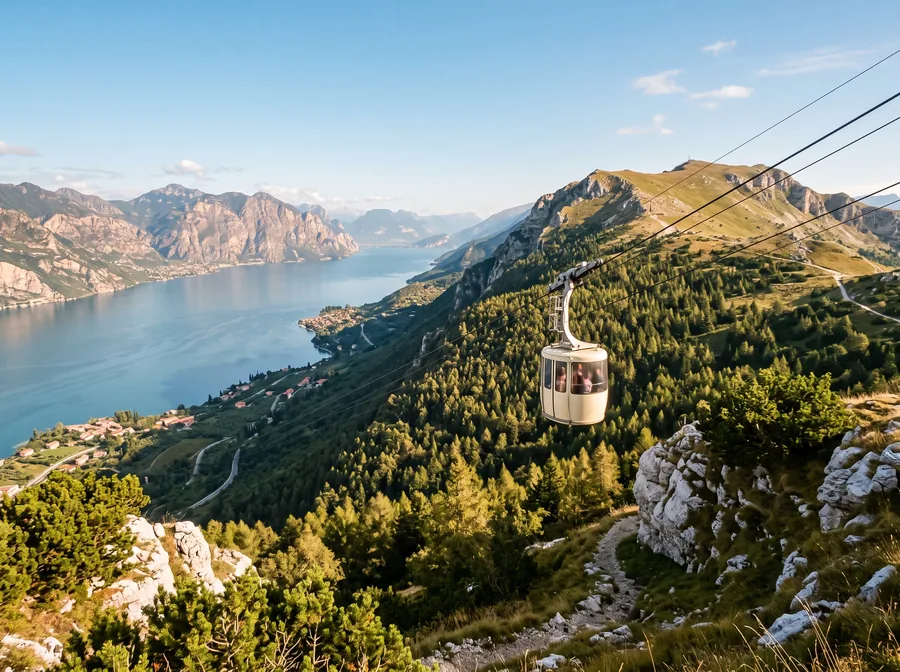 Imagen ilustrativa: cabina de teleférico sobre una ladera boscosa, debajo el Lago de Garda