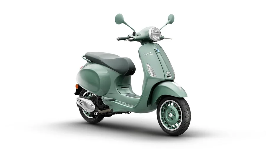 Светло-зелёная Vespa Primavera в студии, снимок спереди сбоку